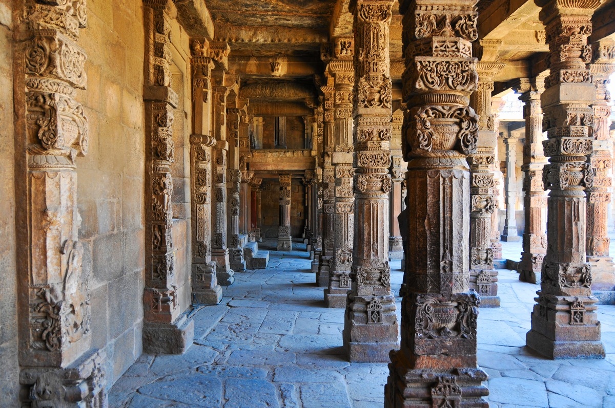 Rows of stone pillars with carvings among the archeological ruins from 13th century India.