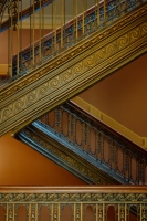 an ornate stairwell: picture of an ornate staircase inside a building in gold brown tones