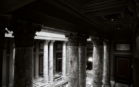 set of pillars flanking the stairwell: Interior of a building with pillars flanking the stairwell lit by sunlight