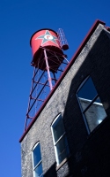 red tank on the roof: a red water tank on the roof of a building