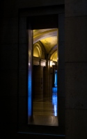 looking out to the corridor through a doorway: corridor lit by blue cold sunlight and warm yellow lights when looking out through a narrow doorway