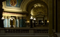 lot of lit lights in the interior of capital building in madison: interior shot of the madison capitol building with pillars and murals