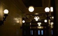 a set of lights in the building: a whole lot of lamps and scones and hanging lights inside the capitol building in madison