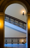 a stairwell with arch : view of a staircase framed by an archway and with warm and cold lighting