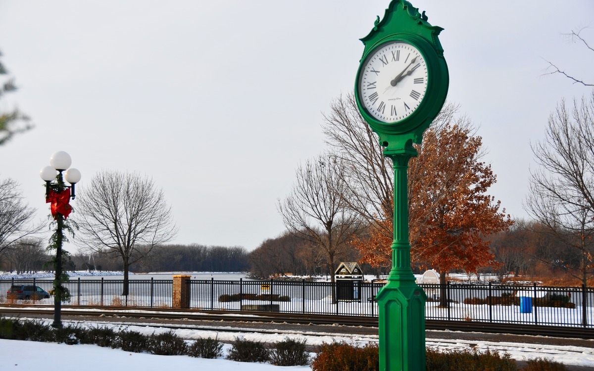 a green clock by the side of the road