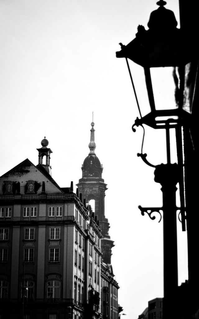 a building, a spire and a street lamp