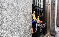 storefront window with mannequins on display and reflections of the buildings on the glass