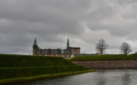 the kornborg castle in denmark with the canal and green lawn