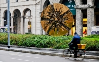 street scene with the cyclist and the sculpture in milan