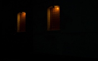 two lit windows along the dark alleyway