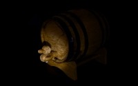 a whiskey cask in the dark lit by a single light source