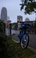 a blue bicycle by the street against the city skyline